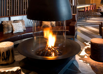 An image of a restaurant setting with a fire, Spa package. The Chedi Andermatt