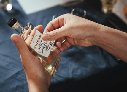 An image of person putting a label on a bottle