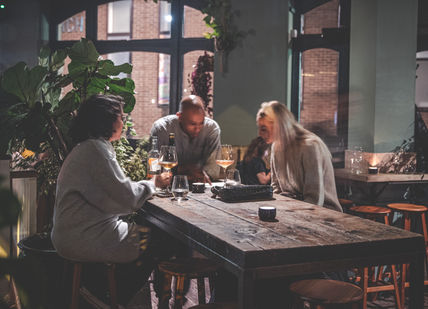 An image of a couple sitting at a table, Wine Tasting Flight. Diogenes the Dog 