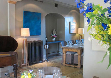 An image of a living room with a piano and flowers, Four-Course Dinner. The Dysart Petersham