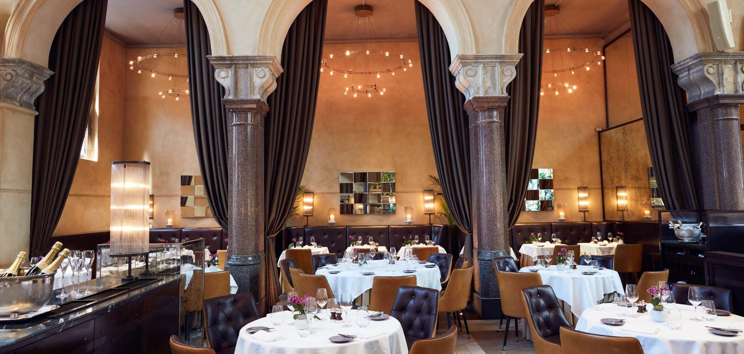 An ornate dining room with tables and chairs.