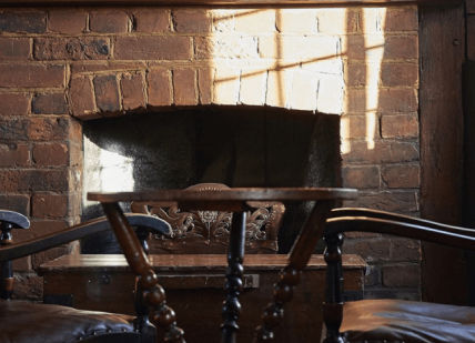 An image of a room with a fireplace and chairs, Four-Course Menu. The Hind's Head, Bray