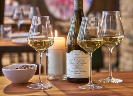 An image of a table with wine and a candle, Premium Wine Tasting. Humble Grape