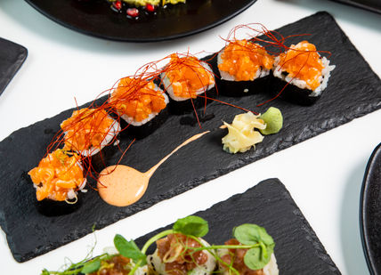 An image of a table with plates of food, Comedy Night and Dinner. inamo Restaurants