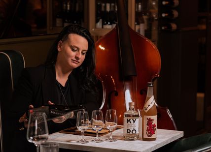 Image of a woman pouring sake on wine glasses