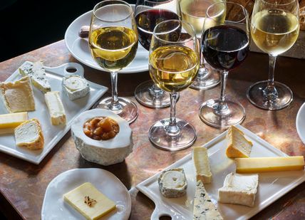 An image of cheeses on a black background, Cheese and Wine Pairing. Le Bar