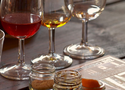 An image of a table with wine glasses and a menu, Premium Spiced Rum Creation Class. Liquor Studio