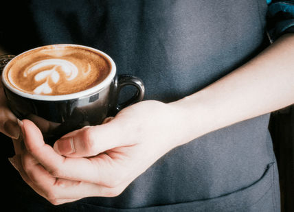 An image of a person holding a cup of coffee, LSC Basic Baritsa Coffee Experience. London School Of Coffee