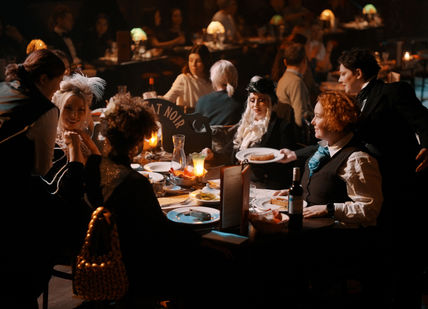 An image of people having a dinner and a show