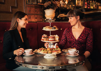 An image of two women having a meal, Map Maison Tapas-Style Afternoon Tea. Map Maison