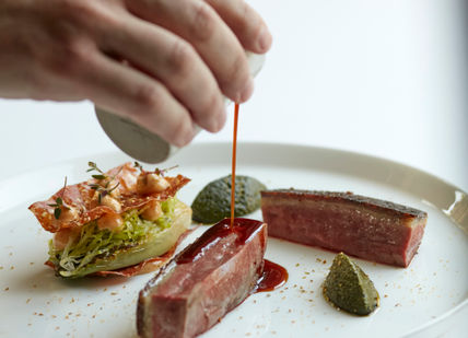An image of a person eating a plate of food, 5 course menu. Marcus