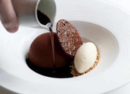 An image of a dessert being served on a plate, 7-Course Tasting Menu. Marcus