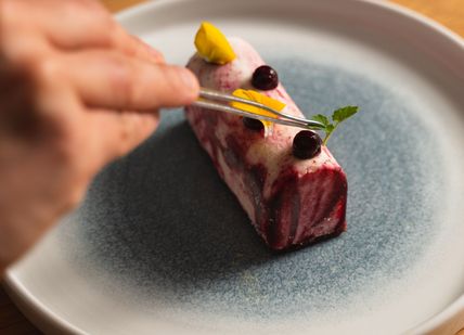 An image of a person eating a piece of food, Four-Course Lunch. Mere Restaurant
