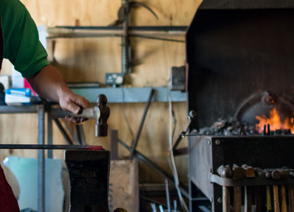An image of a man working in a wood shop, Blacksmithing Taster Experience. Now Strike Archery