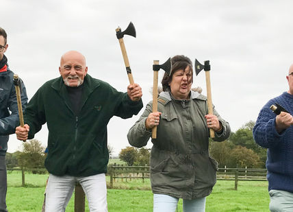 An image of four men holding shovels and standing in a field, Viking Axe Throwing Session. Now Strike Archery