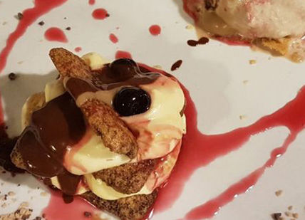 An image of a plate of food with chocolate and fruit, Cooking course. Osteria Della Corte Restaurant