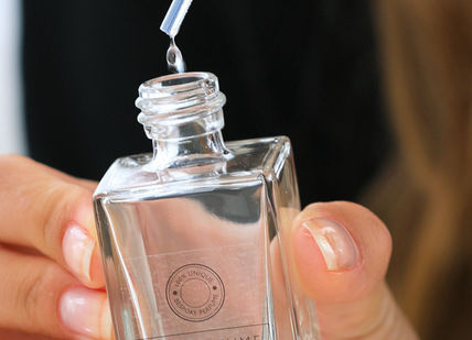 An image of a woman holding a perfume bottle, Platinum experience with Afternoon tea. The Perfume Studio