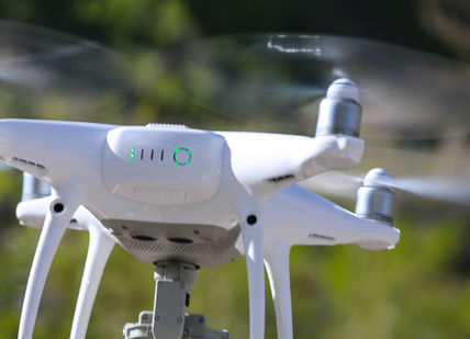 An image of a white drone flying in the air, Private One Hour Drone Lesson. PhantomFlightSchool
