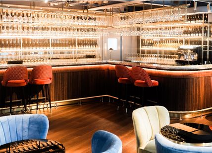 An image of a bar with blue chairs and a bar, Procesecco Tasting . Prosecco House