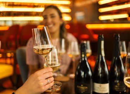 An image of a woman holding a glass of wine, Procesecco Tasting . Prosecco House