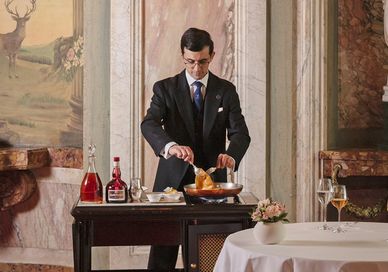 an image of a person serving a meal. The Ritz