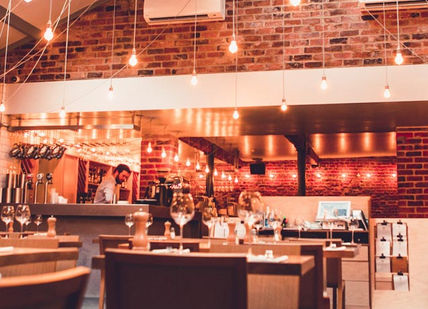 An image of a restaurant with brick walls, Exclusive Tasting Menu with Wine Pairing. Shears Yard