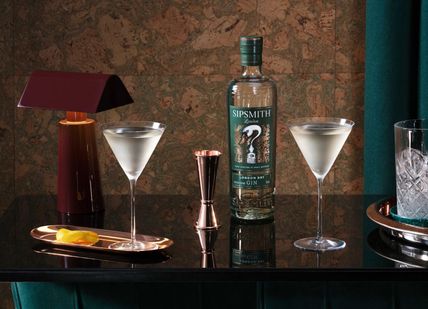 An image of a bar with a bottle of gin and two glasses, Gin masterclass. Sipsmith Distillery