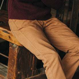 fit model wearing The Camp Pant in Tobacco Boss Duck, sitting on bench