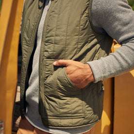 fit model with his hand in the pocket of The Able Vest in Quilted Army