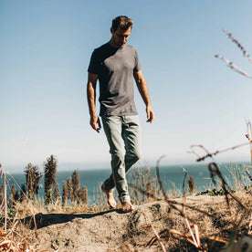 our fit model wearing The Slim Jean in 24-Month Wash Japanese Selvage—walking on the beach, looking down