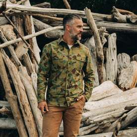 our fit model wearing The Yosemite Shirt in Arid Camo—on a beach, looking right