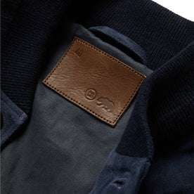 material shot of The Aviator Jacket in Midnight Suede's leather tag patch