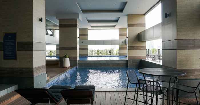 Swimming Pool Homey and Modern 2BR Apartment at Maqna Residence By Travelio