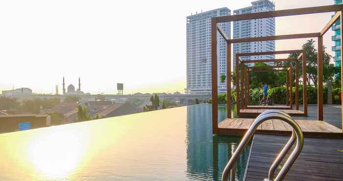 Kolam Renang 2BR Modern Grand kamala Lagoon Apartment By Travelio