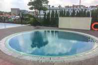 Swimming Pool Homey and Warm Studio at The Oasis Cikarang Apartment By Travelio