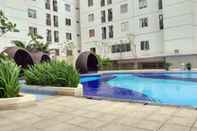 Swimming Pool Cozy Living and Simple Studio Room at Bassura City Apartment By Travelio