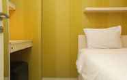 Bedroom 2 Warm and Minimalist 2BR Bassura City Apartment By Travelio