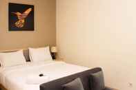 Kamar Tidur Warm and Cozy Studio at Grand Kamala Lagoon Apartment By Travelio