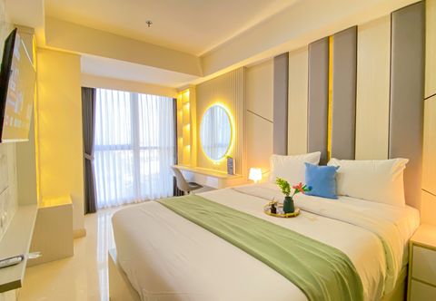 침실 Cozy Living and Modern 1BR at Gold Coast Apartment By Travelio