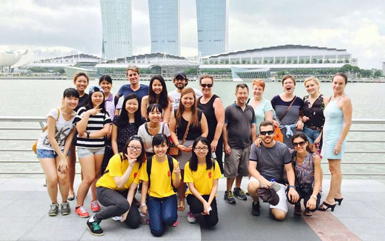 Wearing yellow shirts, young volunteers from the Nanyang Technological University offer tourists a free guided tour of Singapore.