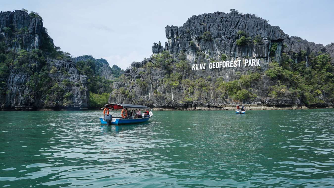 a boat heading towards kilim geoforest park