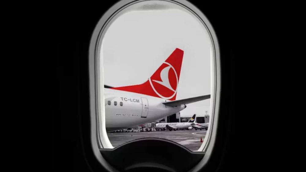 The view out of an airplane window at a Turkish Airlines plane.