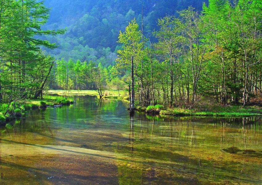 Hồ Tashiro ở Kamikochi yên bình với nước trong xanh phản chiếu núi non và bầu trời.