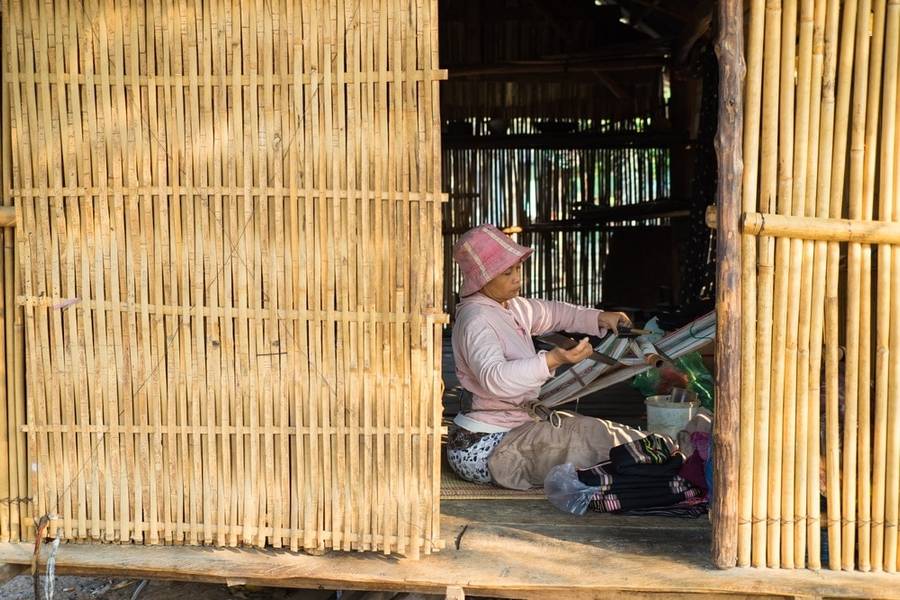 Một phụ nữ người Ba Na đang dệt vải trong nhà tại làng du lịch cộng đồng Kon Kơ Tu