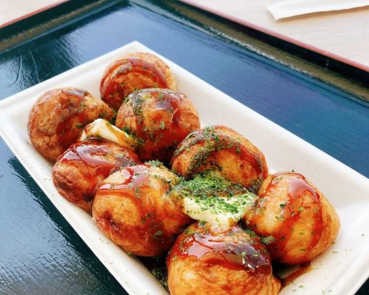 Takoyaki là món ăn vặt Odaiba cực kỳ phổ biến và dễ ăn, được phủ lên lớp sốt mayo béo ngậy, nước sốt Okonomiyaki mặn ngọt và rắc thêm ít cá bào Katsuobushi