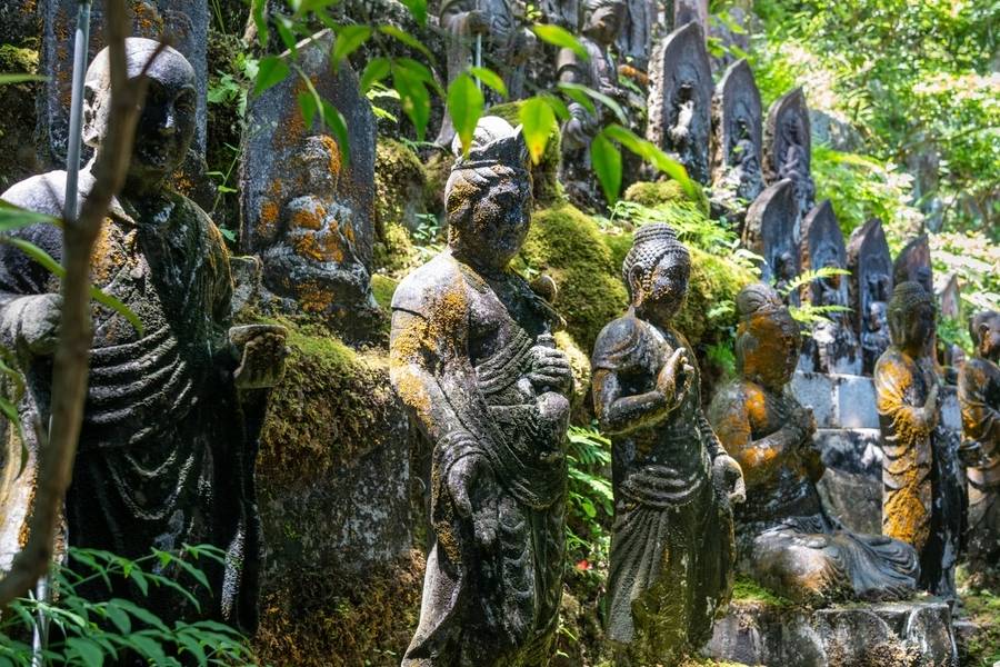 Những bức tượng Phật cổ kính phủ rêu đứng yên bình trong khuôn viên chùa Mitaki. 