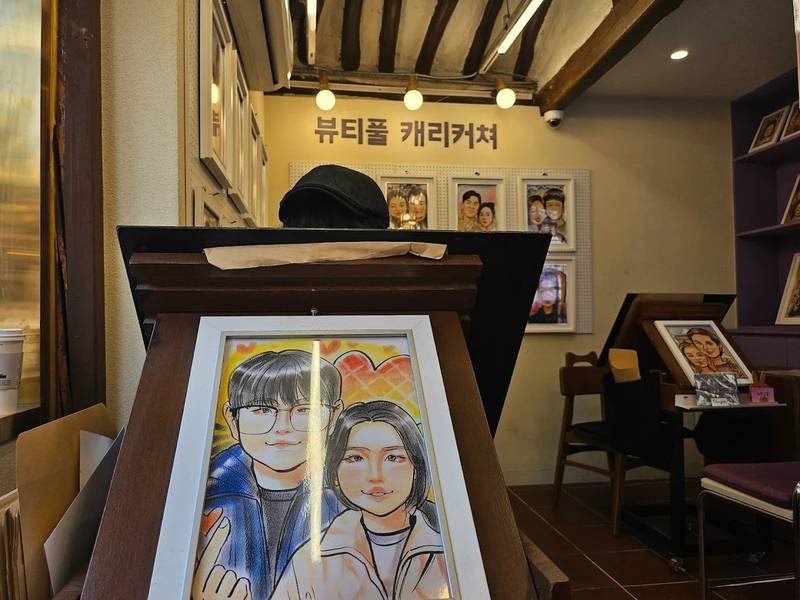 Du khách có thể đặt vẽ tranh biếm hoạ tại các tiệm tranh ở Hanok Ikseon Goro để làm quà lưu niệm