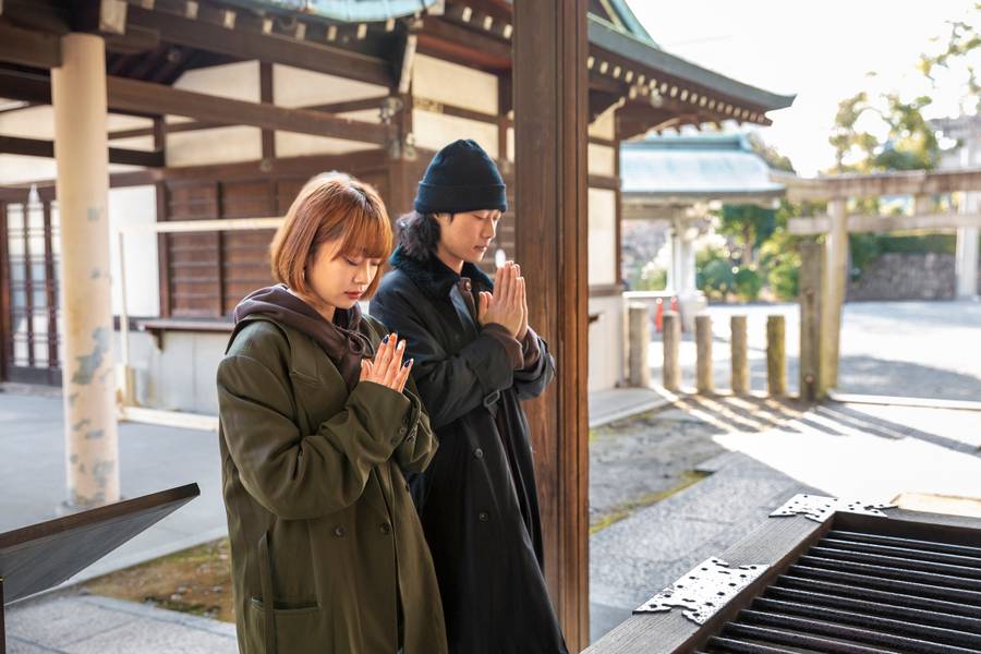Japanese couple praying in temple while on a date