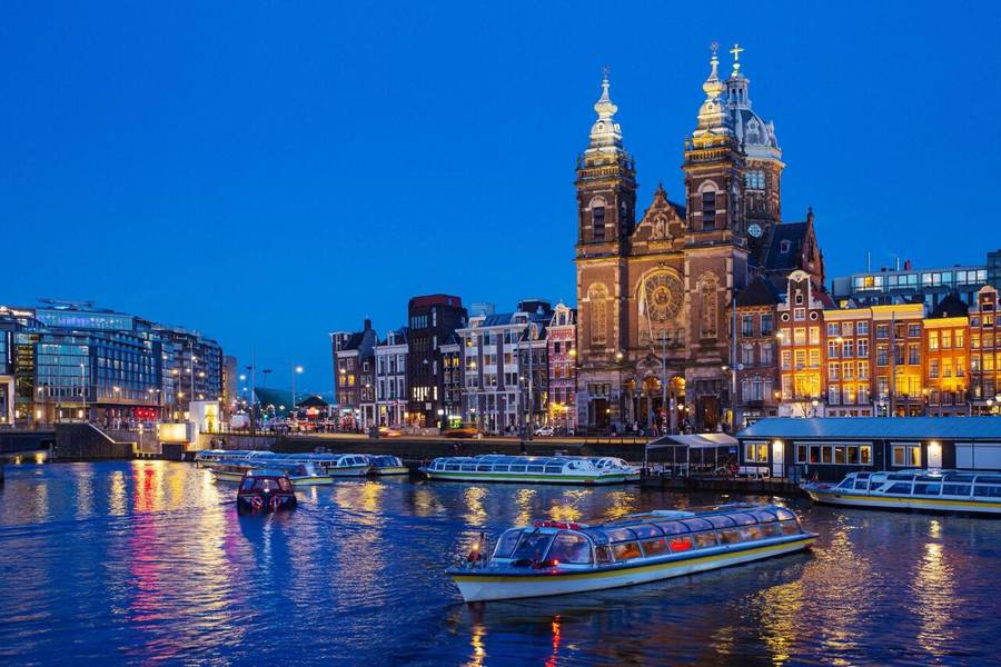 Thánh đường Nicholas lộng lẫy soi bóng mặt kênh trong tour du thuyền đêm trên Kênh đào Amsterdam 