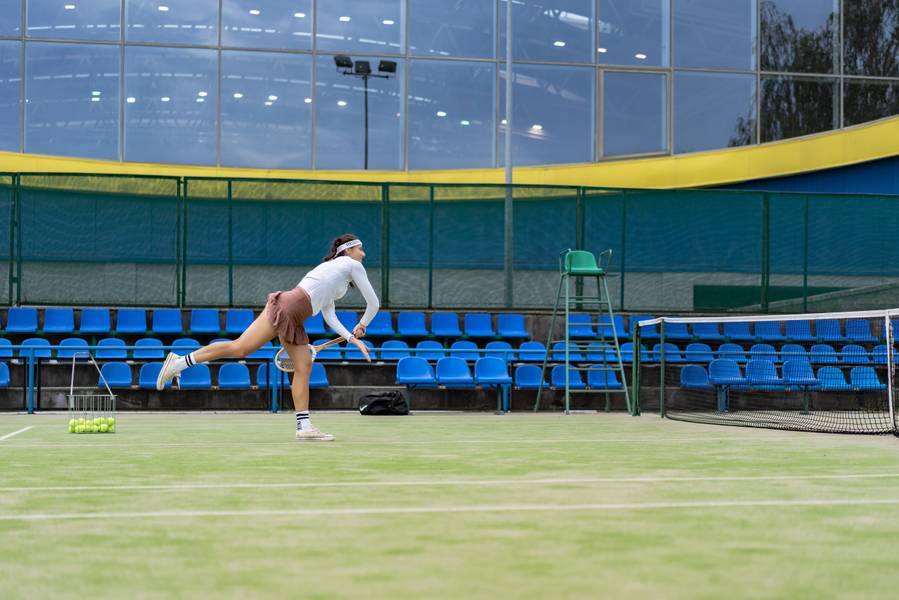 Female tennis player on green court grass